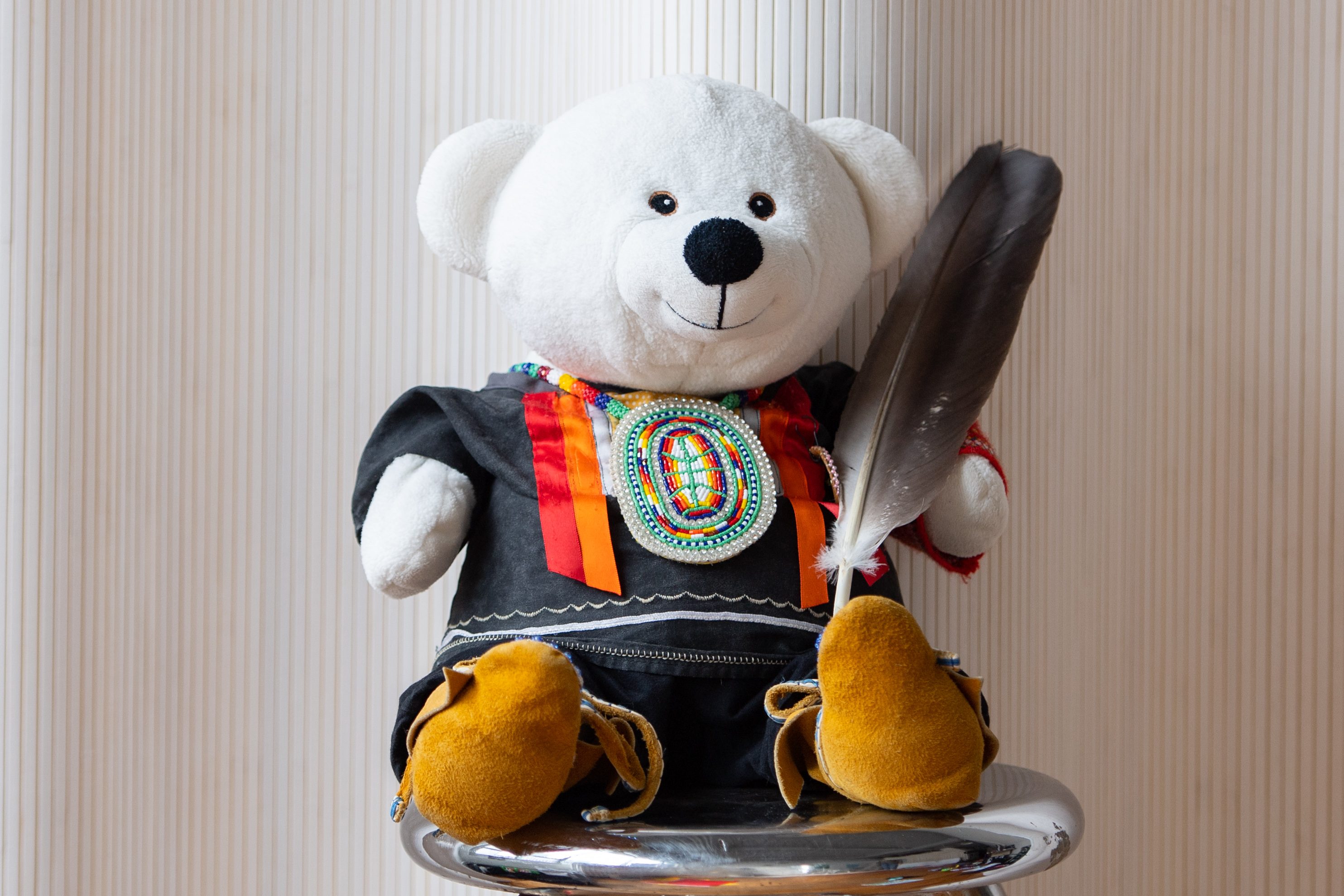 Spirit Bear holding an eagle feather